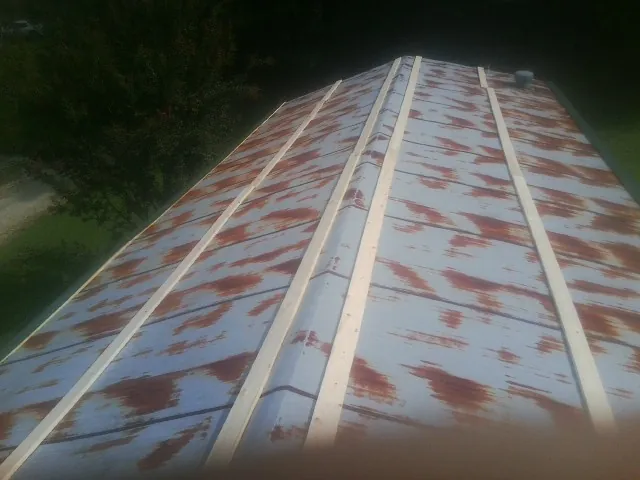 Rusted metal roof panels with new wood purlins before replacement — Storm Damage Roof Repair in Brandon by Roofing Brothers